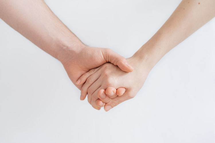 Close-up of hands against white background