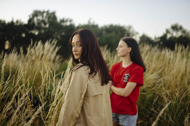 Two women standing in tall grass