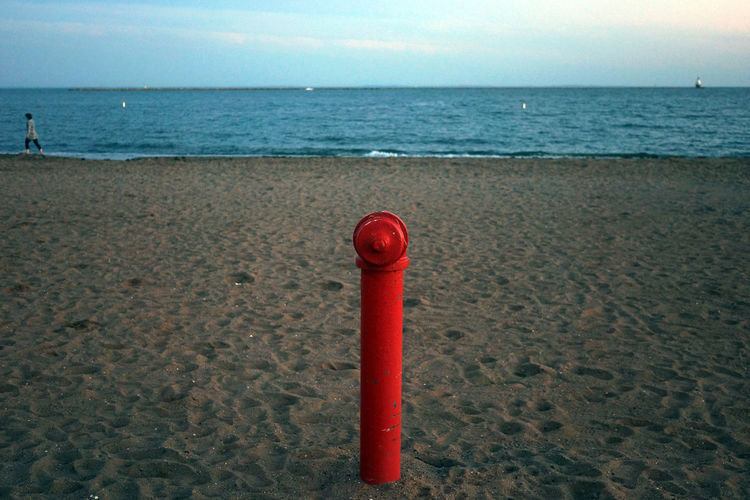 Close-up of red light on beach against sky
