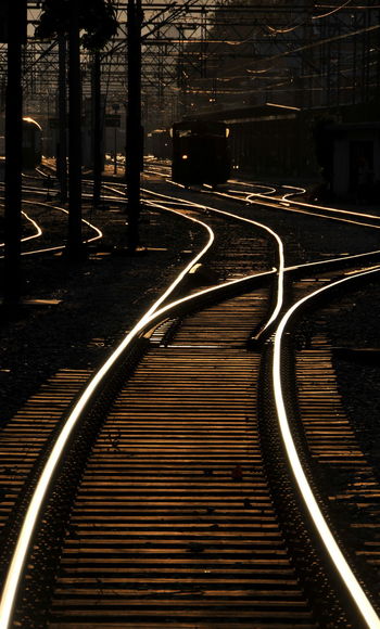 Railroad track on road during sunset
