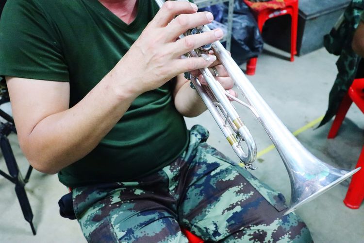 Midsection of man playing trumpet