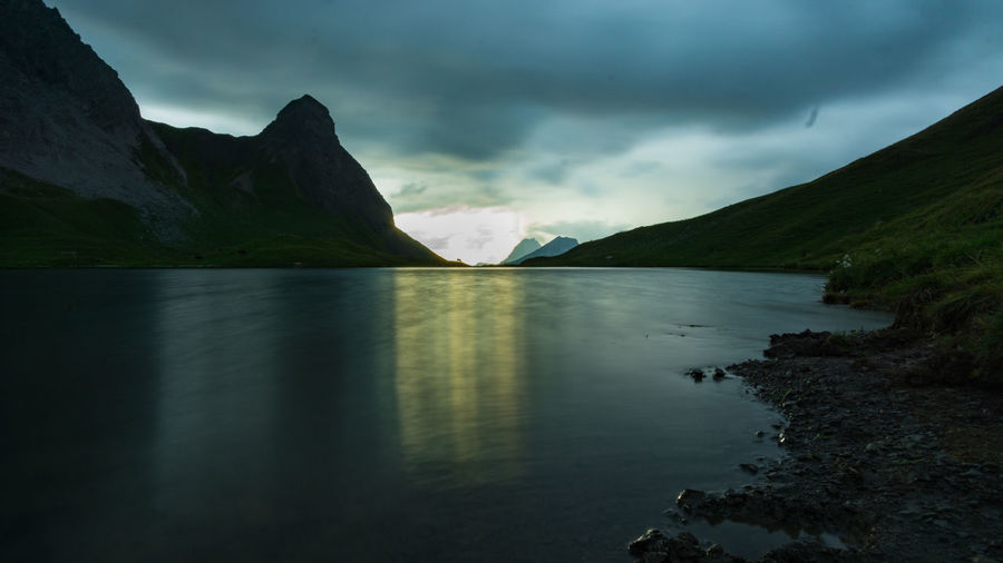 Scenic view of lake and mountains against sky