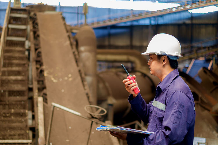 Engineer using walkie-talkie in industry
