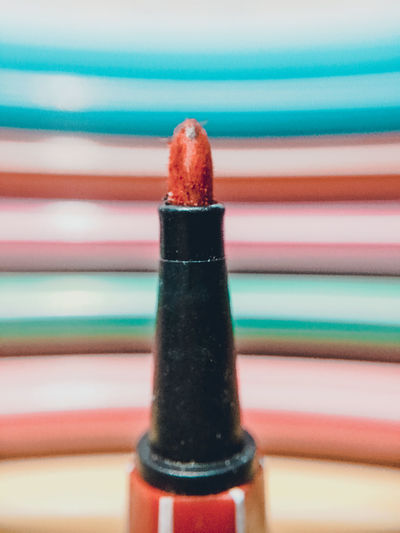 Close-up of felt tip pen with colorful stripes in backgrounds