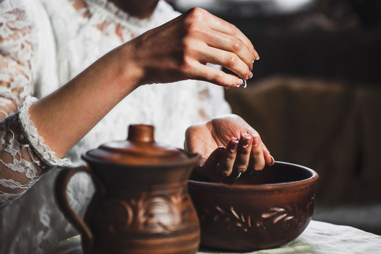 Midsection of woman washing hands on table