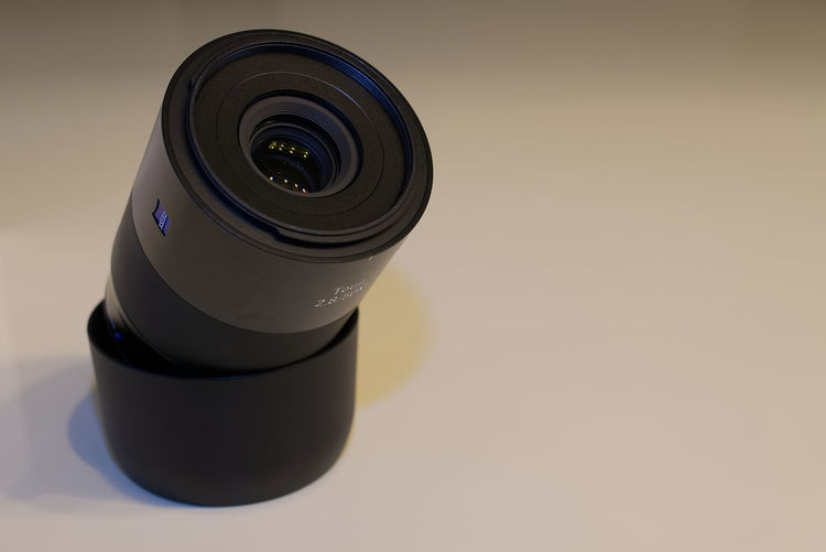 Close-up of camera lens over white table