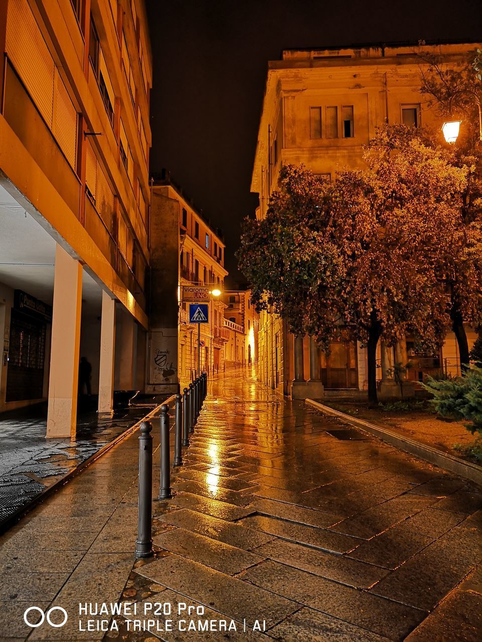 ILLUMINATED STREET BY BUILDINGS AT NIGHT