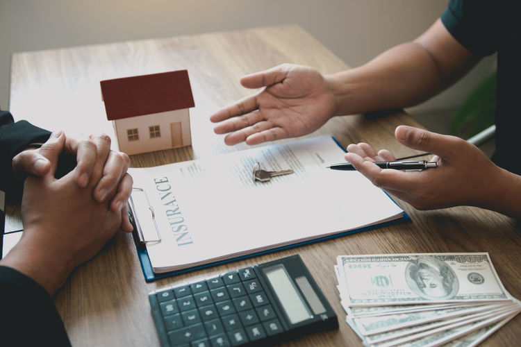 Midsection of estate agent discussing with customer at office