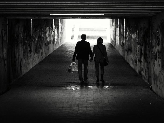 Rear view of man walking in tunnel