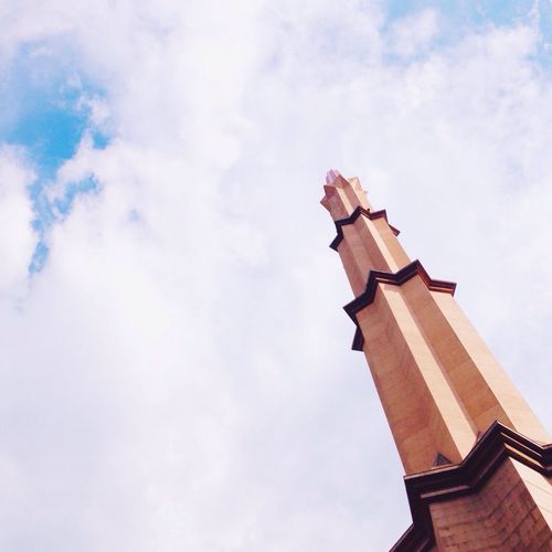 Low angle view of tower against cloudy sky