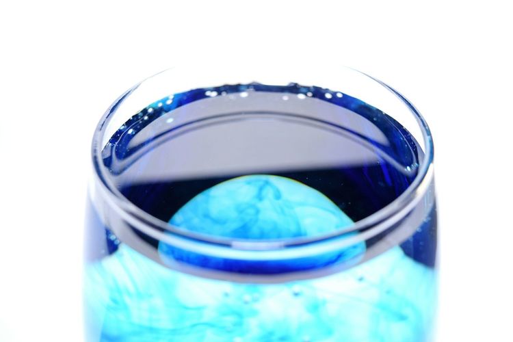 Close-up of blue glass against white background