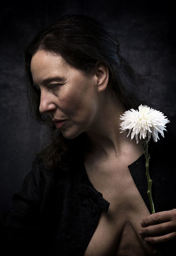 Woman in melancholic attitude with white chrysanthemum viii