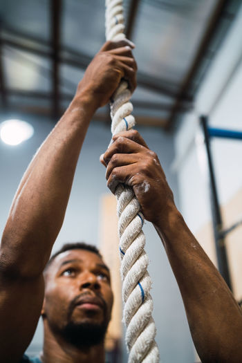 Low angle view of man working on rope