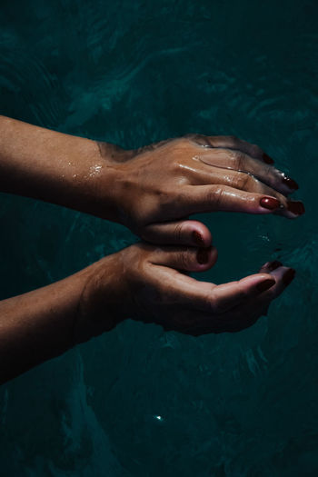 Cropped hand of man swimming in sea