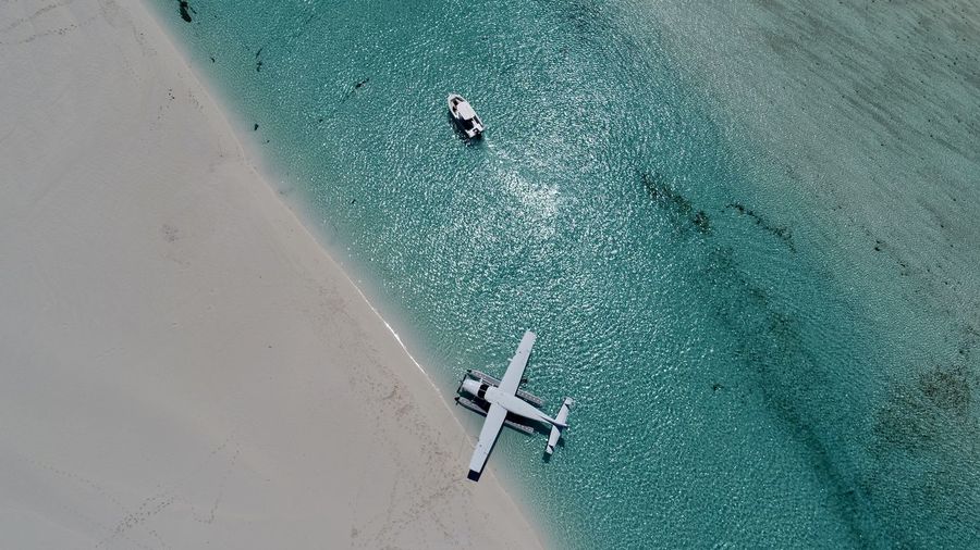 Aerial view of seaplane and boat in sea