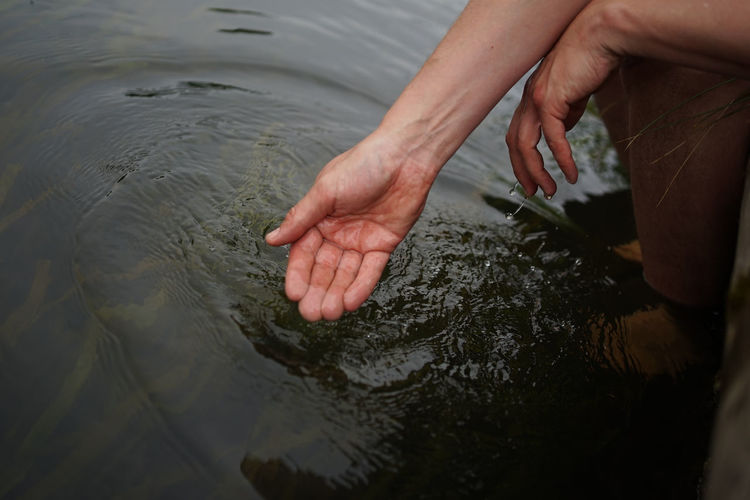 Hands dipping in river water