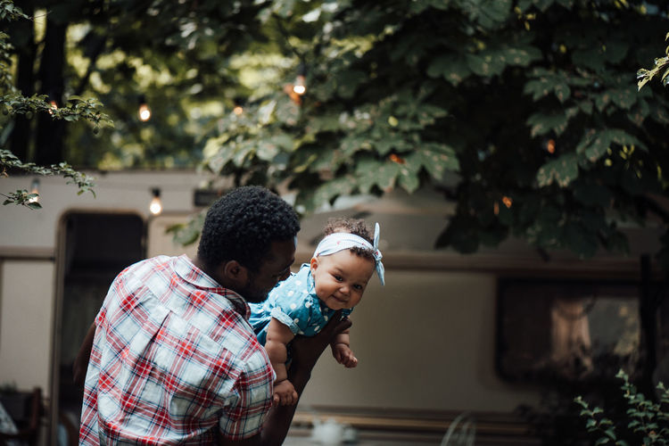 Father carrying daughter on shoulder outdoors