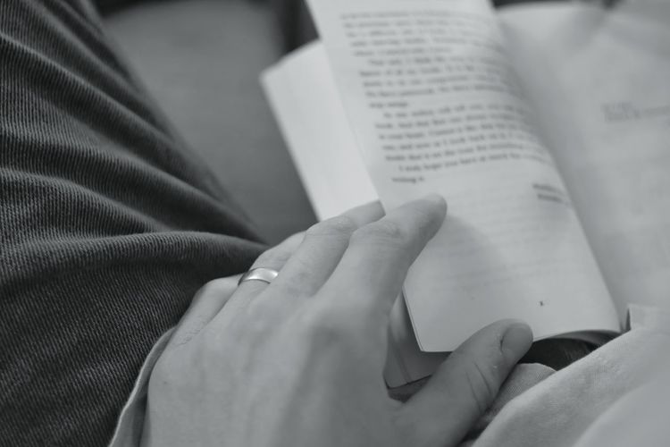 Cropped hand of person reading book