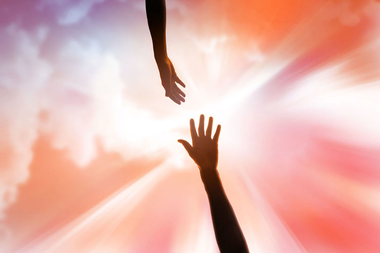 Religious arm of human held up high in the sky to ask for rescue of god and gets a helping hand