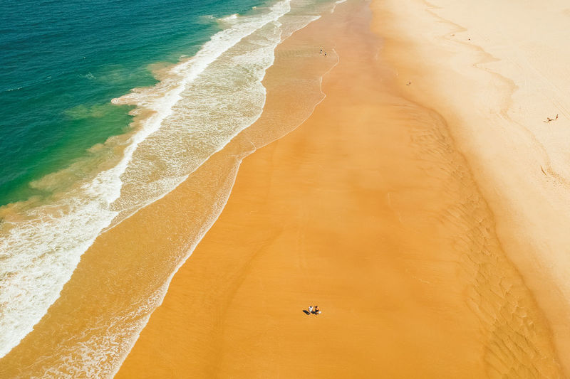 High angle view of two people walking along beach in gold coast, australia