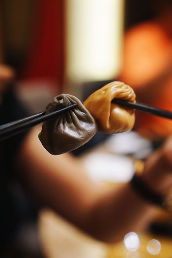 Close-up of dumplings held by chopsticks