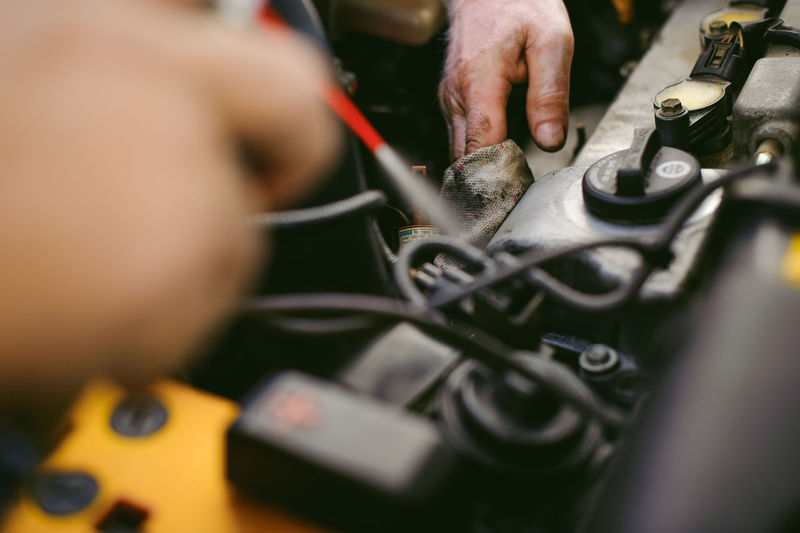 Close-up of hands repairing car engine