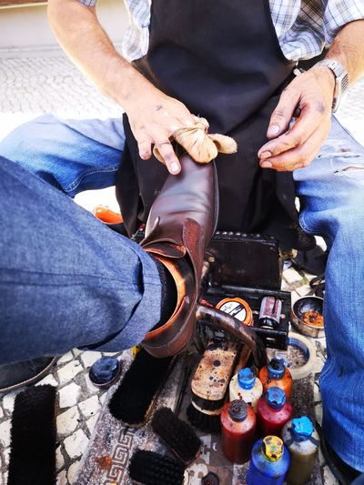 Man polishing shoe of customer in city