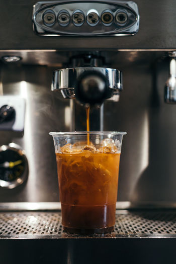 Coffee espresso extraction from espresso machine into glass