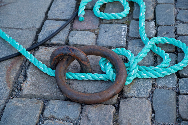 High angle view of rope tied on metal chain