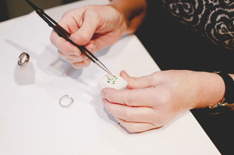 Cropped image of senior female craftsperson assembling jewelry in workshop