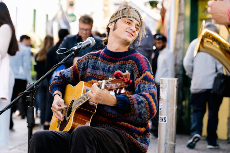 Young man playing guitar in the street