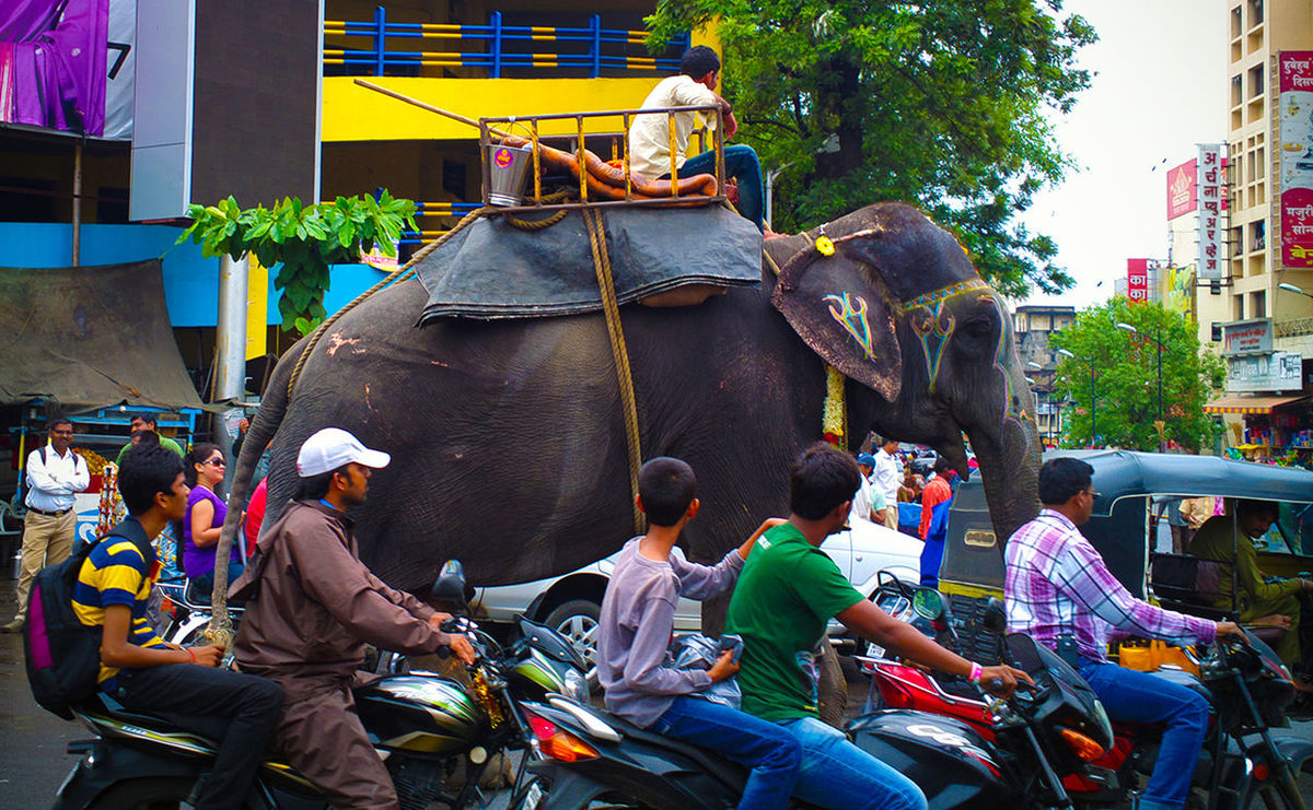men, lifestyles, building exterior, leisure activity, casual clothing, architecture, built structure, person, land vehicle, street, large group of people, occupation, city, day, city life, mode of transport, outdoors, transportation