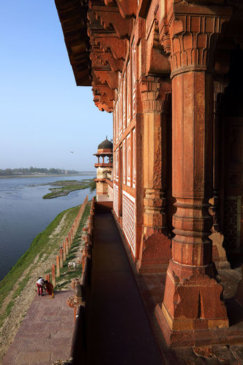 Agra fort by lake against clear sky
