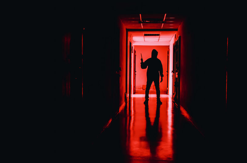 Silhouette criminal standing in corridor of building