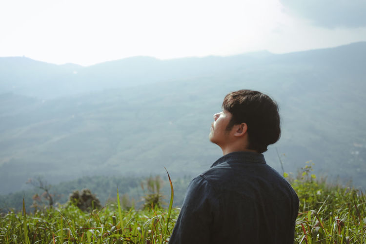 Man standing on field against mountains