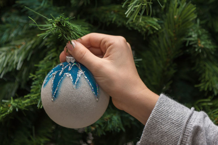 Cropped hand holding christmas ornament
