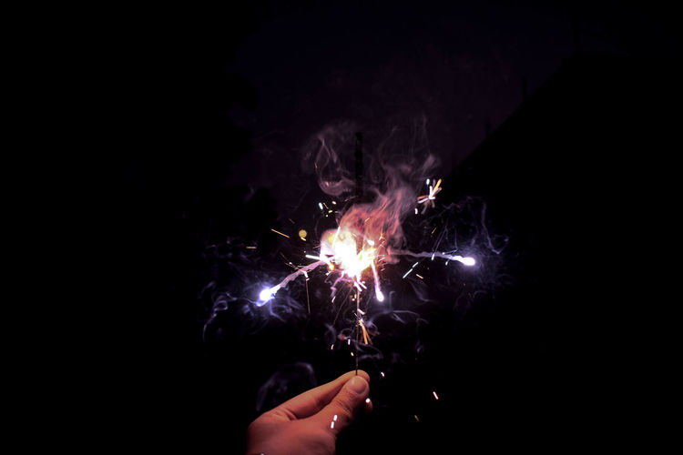 Person holding firework display at night
