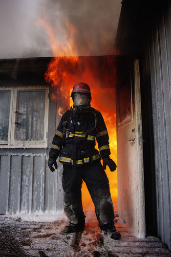 Fire fighter in front burning house