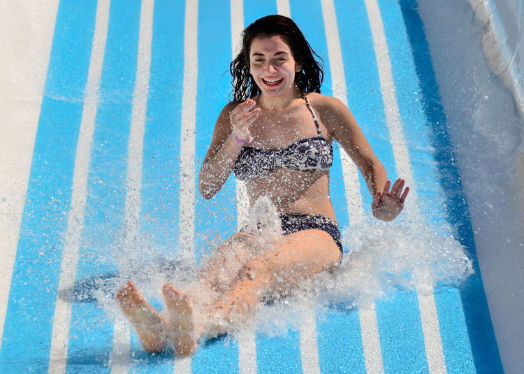 Portrait of smiling young woman on water slide