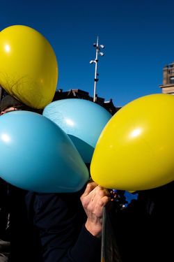 midsection of woman with balloons against sky