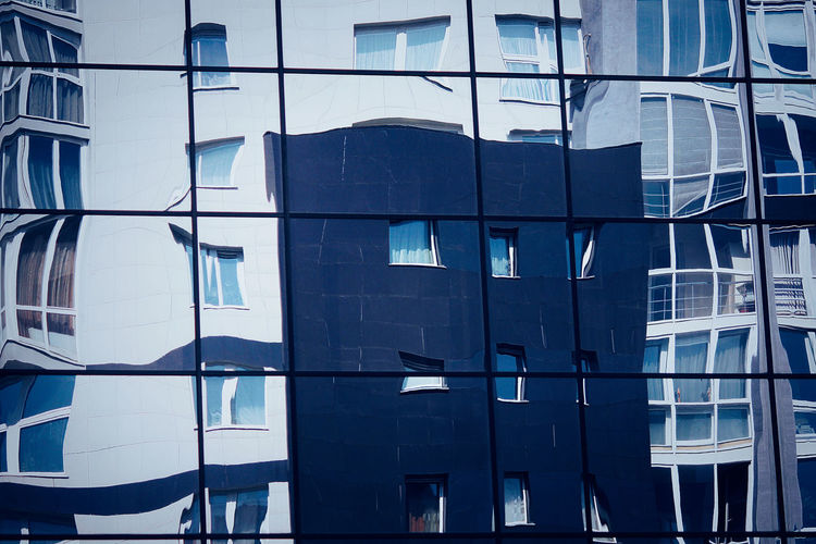 Distorted reflection of the city architecture. light blue background of glass modern building. 