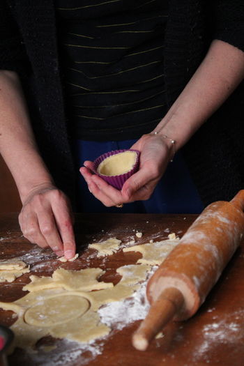 Cropped hands of woman baking muffin or cupcake dough