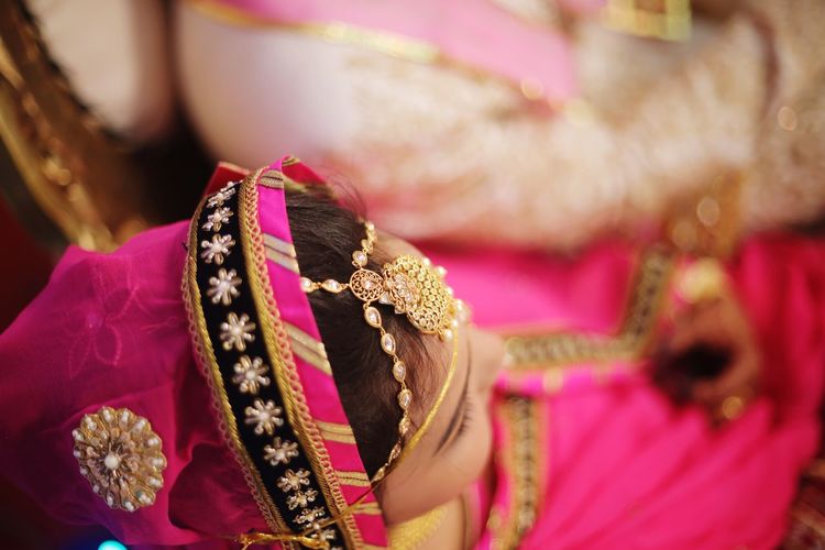 Close-up of bride wearing sari and jewelry during wedding ceremony