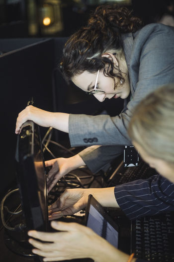 Female business professionals checking computer at workplace