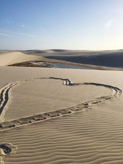 Heart shape at desert against sky