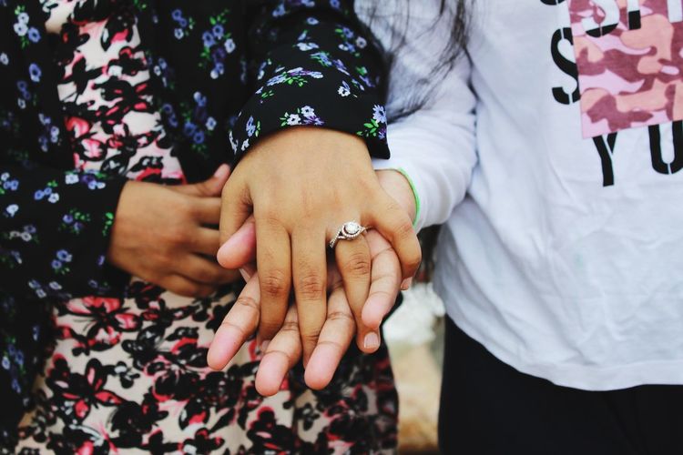 Midsection of women holding hands