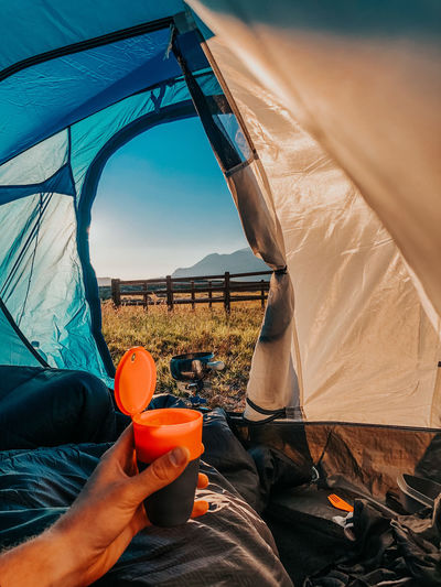 Cropped image of man holding tent