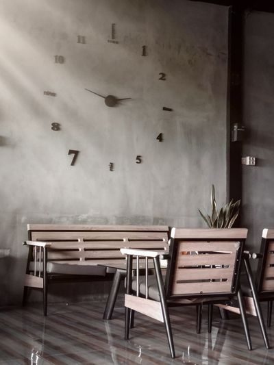 Empty chairs and tables against wall in building