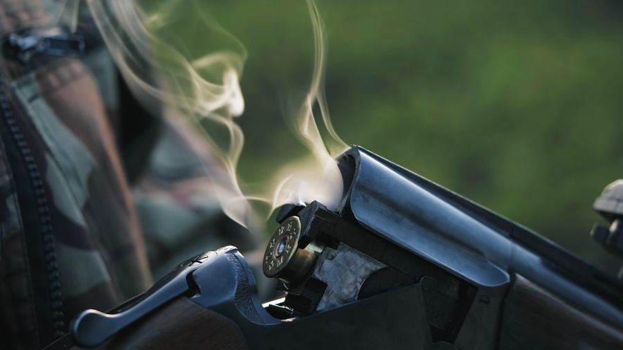 Cropped image of person holding rifle