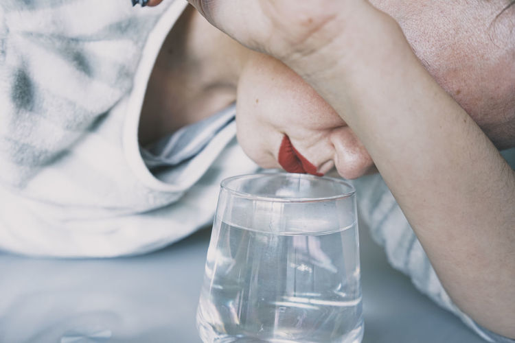 Close-up of woman holding glass of water